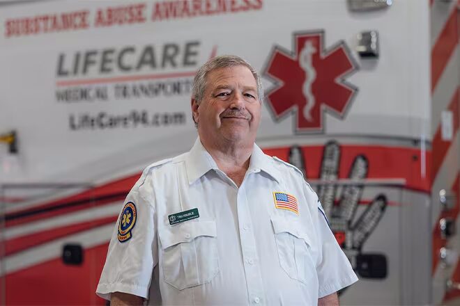 Timothy Kimble First Responder Standing Next to Ambulance
