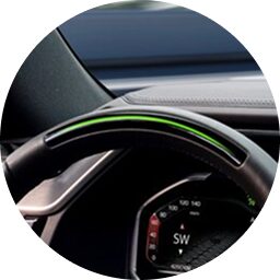 Steering wheel with illuminated green light bar indicating Super Cruise is active.