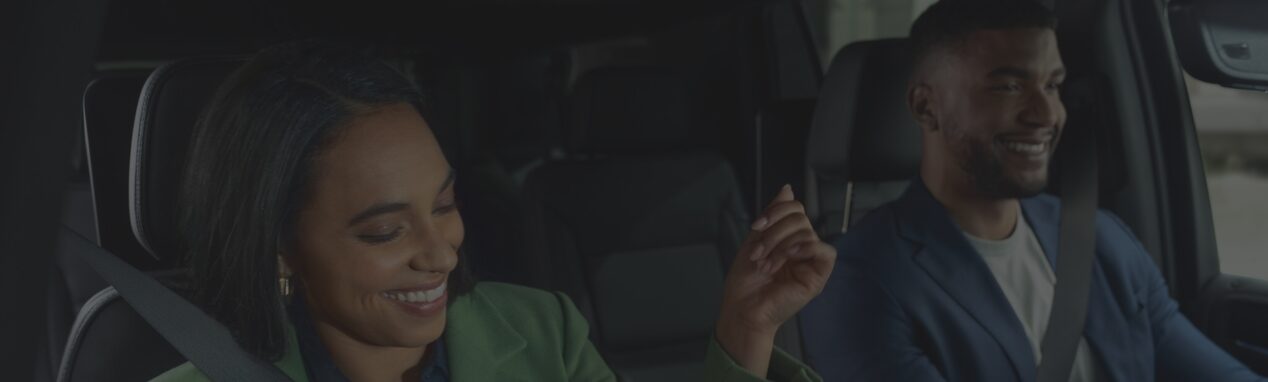 Two happy people seated at the front row of an OnStar-subscribed vehicle.
