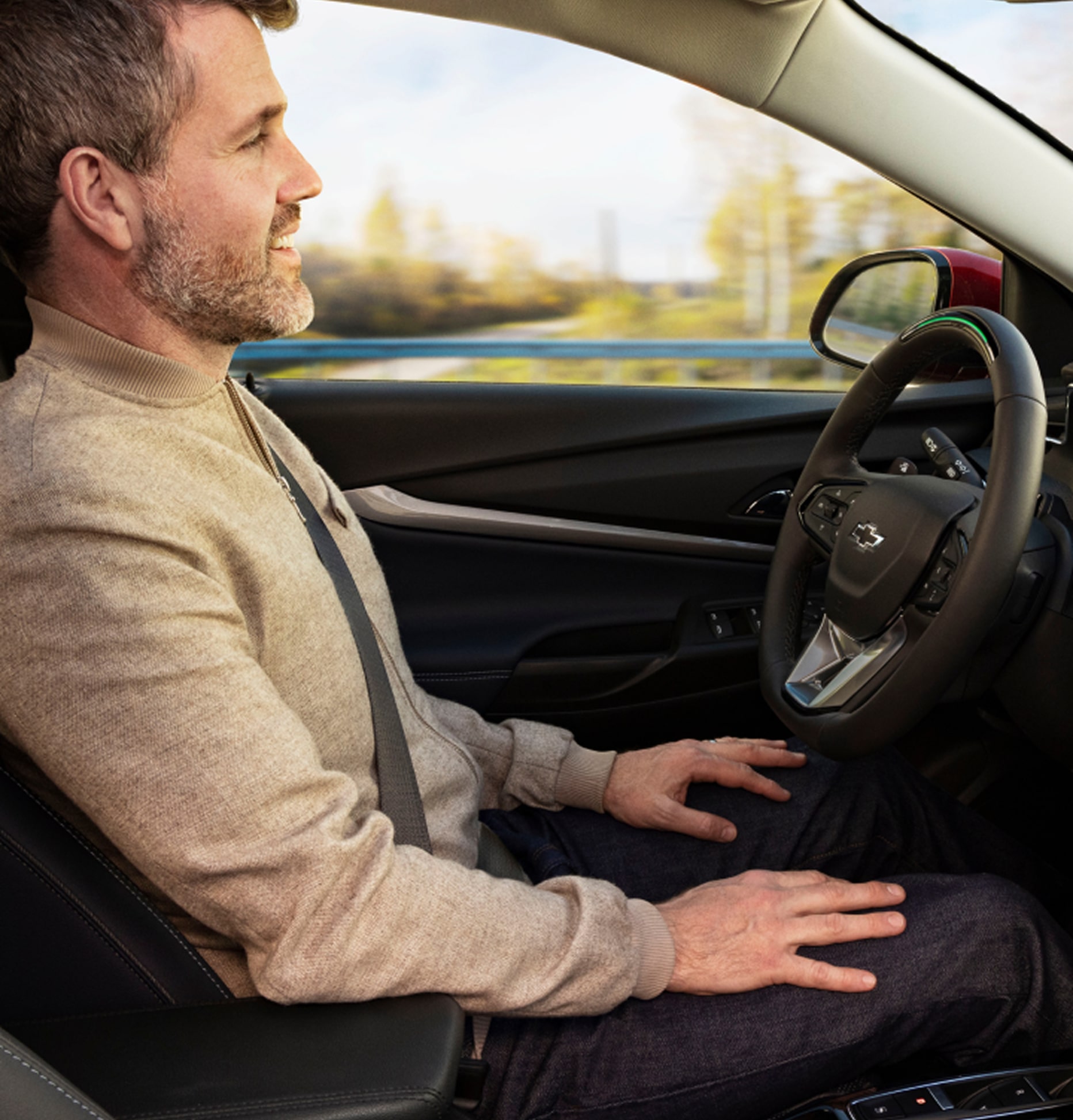 Man Sitting in Drivers Seat Using GM Super Cruise Hands-Free Technology