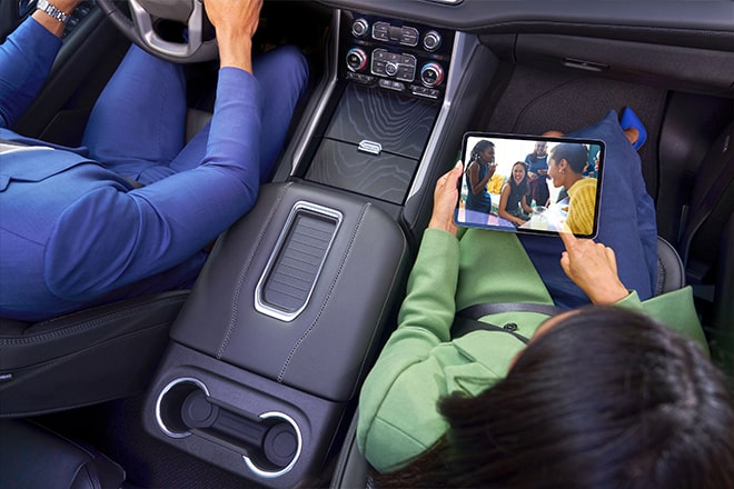 Birds-eye view of a man driving and a woman using an iPad in the passenger seat