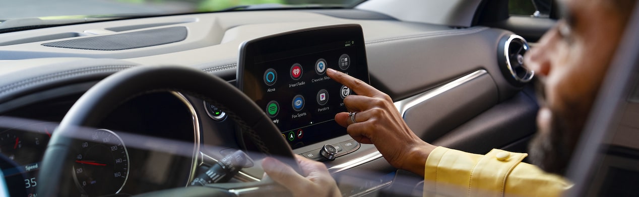 Driver pressing an app on his vehicles entertainment system