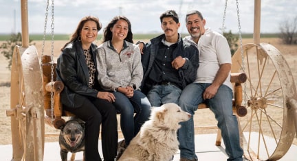 Family Sitting Together Outside with Their Dog