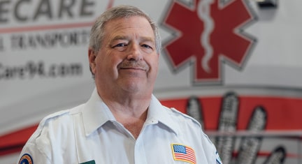 Timothy Kimble First Responder Standing Infront of an Ambulance