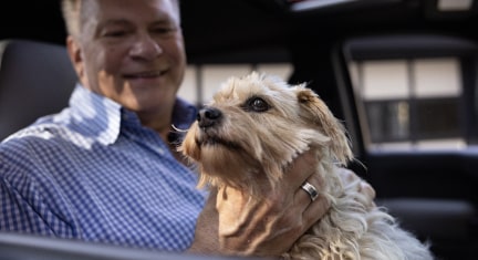 Snickers the dog being held by his owner Larry