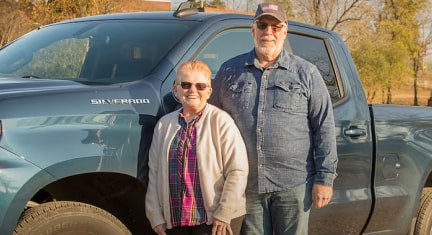 Glen and Roxanne Standing in Front of their Chevy Truck