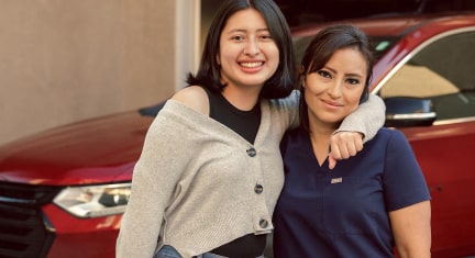 Glenis and her Daughter Hugging In Front of her Chevy Traverse