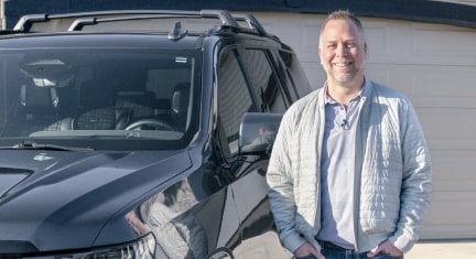 Justin smiling while standing next to his 2021 Cadillac Escalade