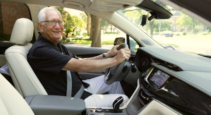 OnStar member Wayne Stoeber smiling while in the driver seat of his GM vehicle