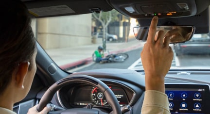 Man pressing OnStar Button in Vehicle