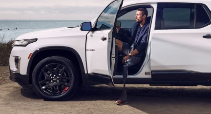 A man with a prosthetic leg stepping out of his GM vehicle