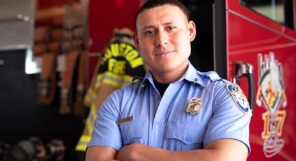 Firefighter Crossed Armed and Smiling in Front of Firetruck
