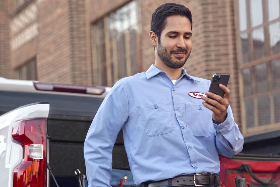 Two Men Looking at a Tablet in Front of AutoZone