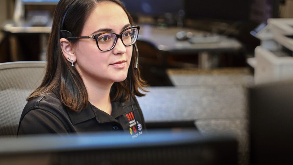 Woman Wearing Glasses in an Office Looks at Her Desktop