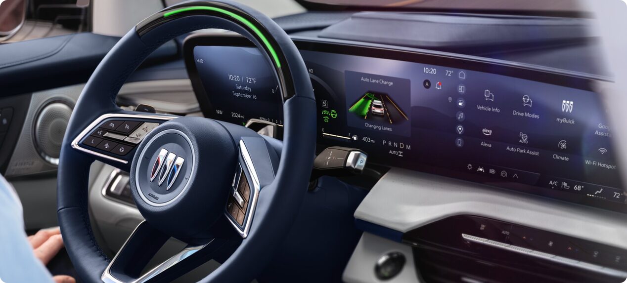 Light green indicator on the Buick steering wheel and driver display showing Super Cruise automatically changing lanes while driving hands-free on a highway.