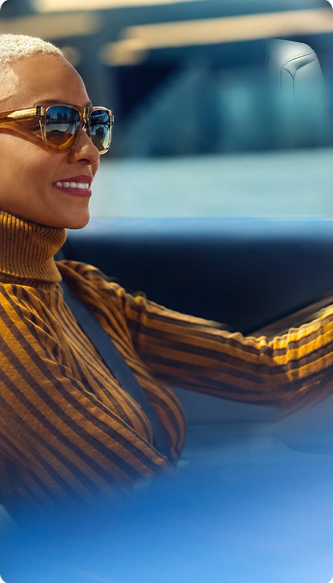 A woman driving a vehicle, highlighting the connected vehicle technology experience with OnStar.