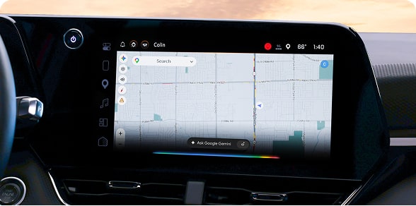 A car's infotainment screen displays Google Maps with a route selected.