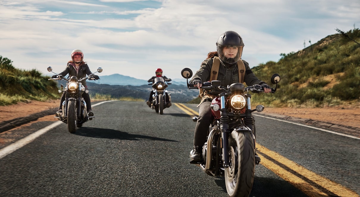 Three Motorcyclists Riding Down the Road Wearing Helmets