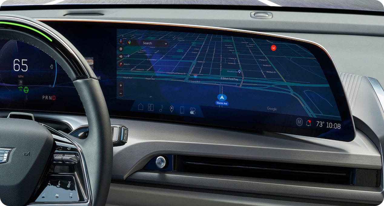 A car's digital dashboard display shows a navigation map, speedometer, and other vehicle information.