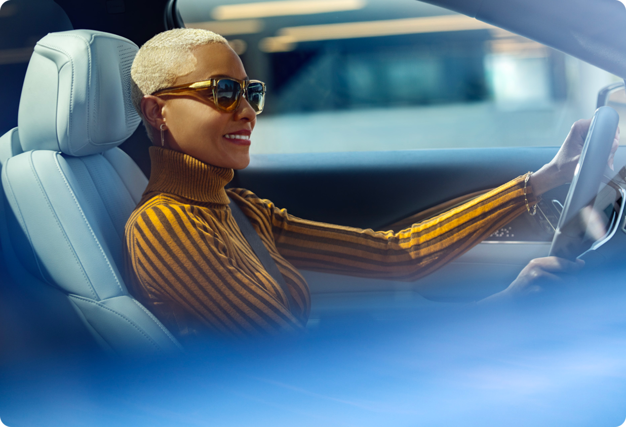 A woman driving a vehicle, highlighting the connected vehicle technology experience with OnStar.
