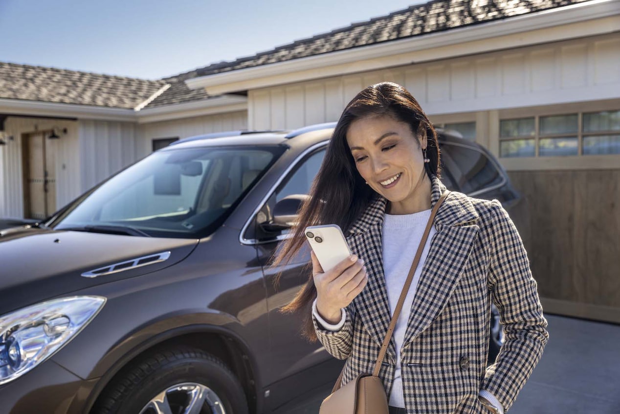 Woman Standing in Driveway Next to GMC Vehicle on her Smartphone