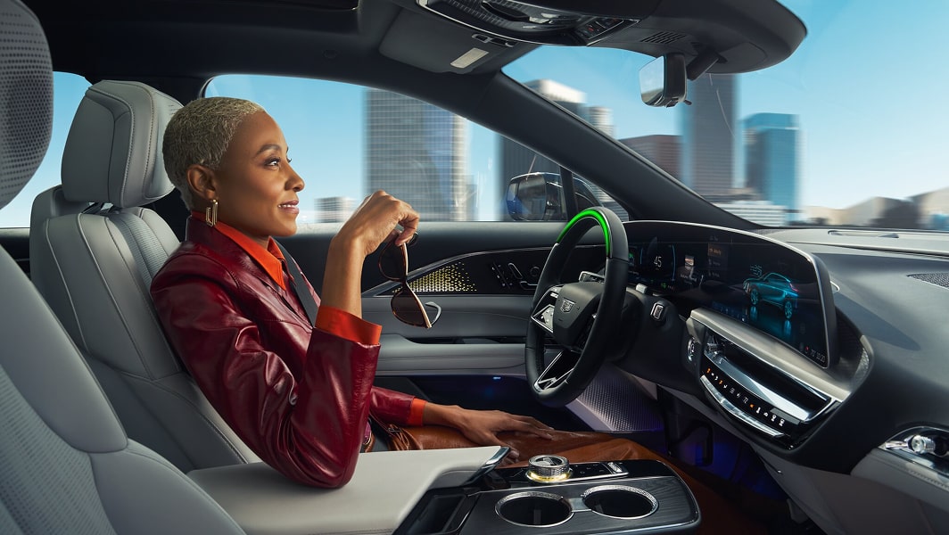 A woman in the driver seat of a vehicle utilizing the Super Cruise hands-free driving feature.