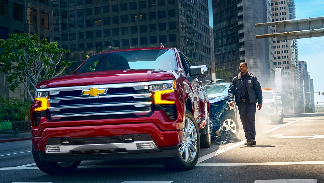 A first responder walking up to a Chevy truck that was in an accident.