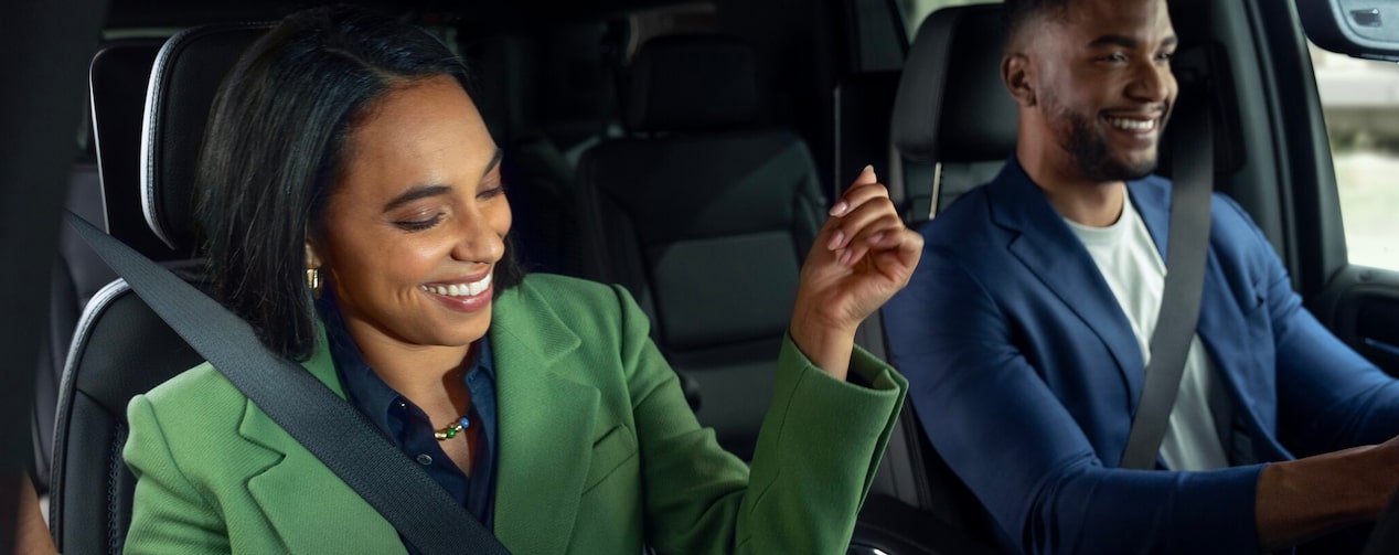 A man driving a vehicle with a woman in the passenger seat.
