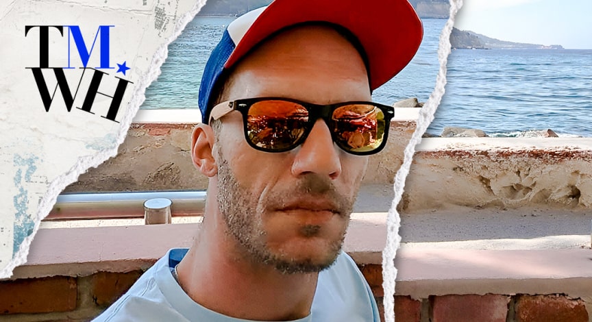 A man with hat wearing a sunglass on a bridge next to the text overlay of "Tell Me What Happened".