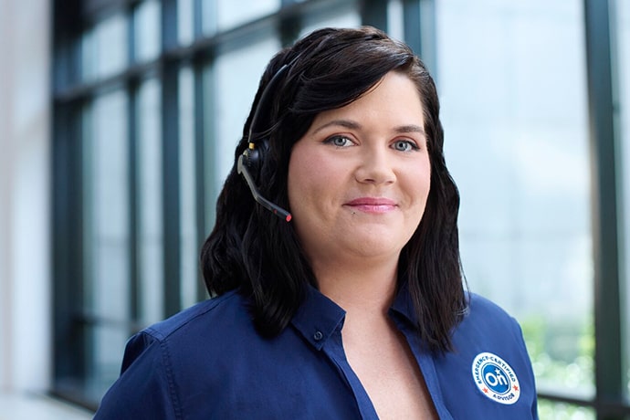 A female OnStar advisor smiling at the camera with her headset on