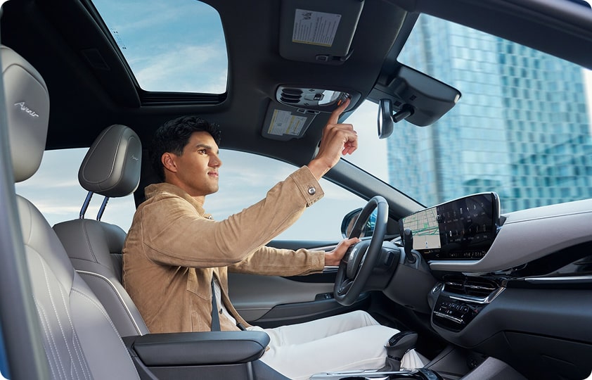 Man in a car pressing the OnStar roadside assistance button.