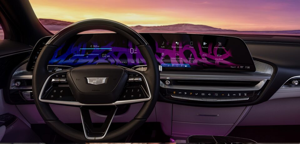 Drivers Seat View of the Steering Wheel and the Infotainment System with a Purple Hue