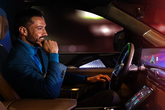 Side view of a man on the driver's seat smiling while looking ahead.