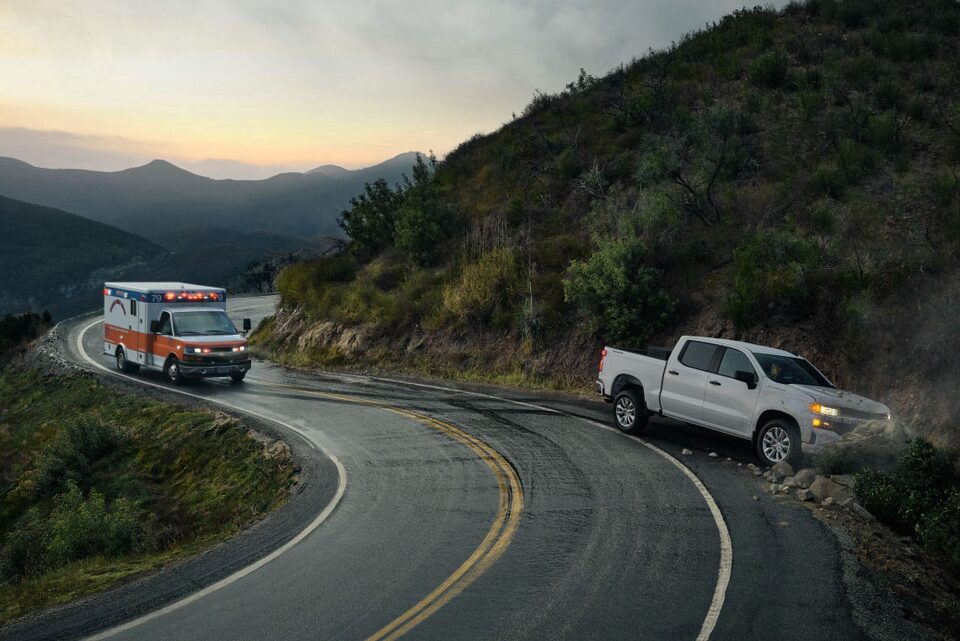 Ambulance Approaches a Crashed Truck on a Mountain Road