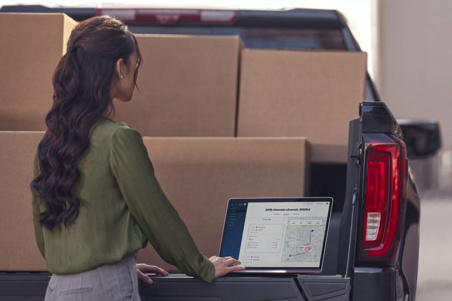 Two People Wearing Aprons Standing at the Rear of a Work Van