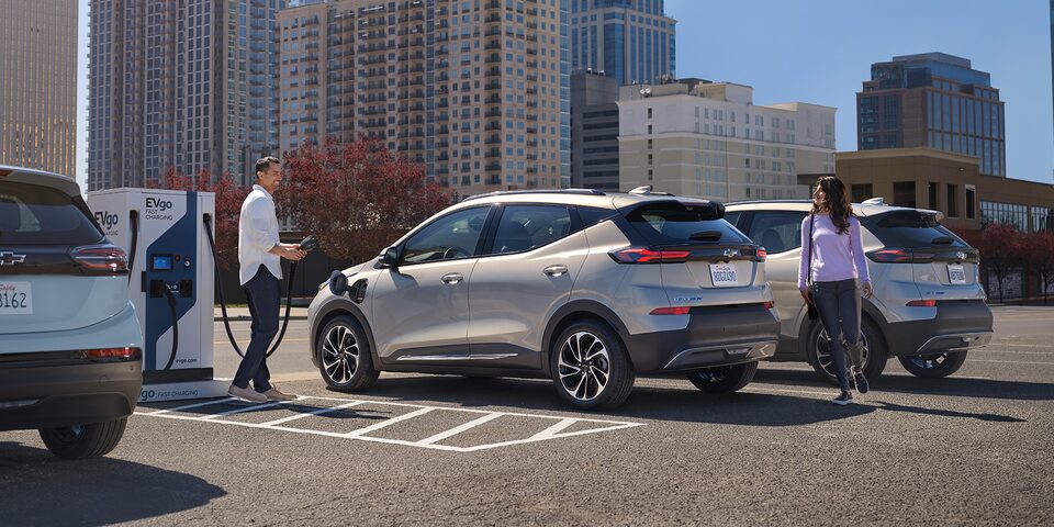 Couple at Public Charging Station Charging Their EV Vehicle