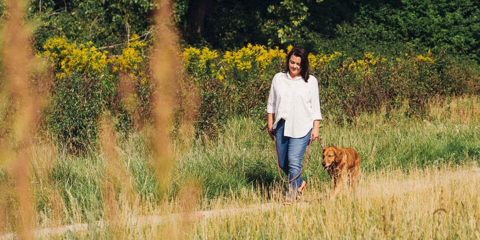 Women Walking her Dog Through a Feild