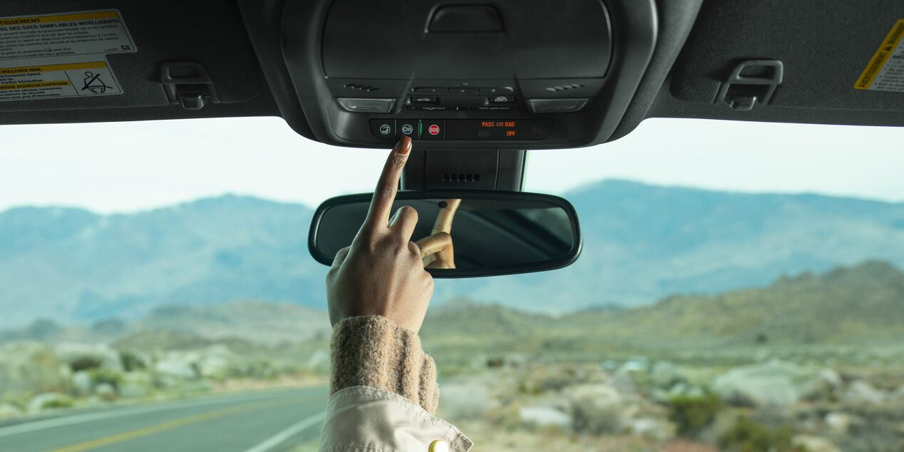 Driver Pressing the OnStar Button in Vehicle