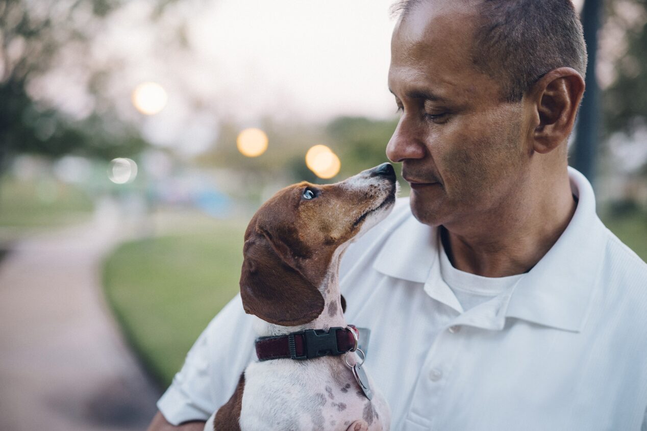 Man Holding Dog Looking at Each Other