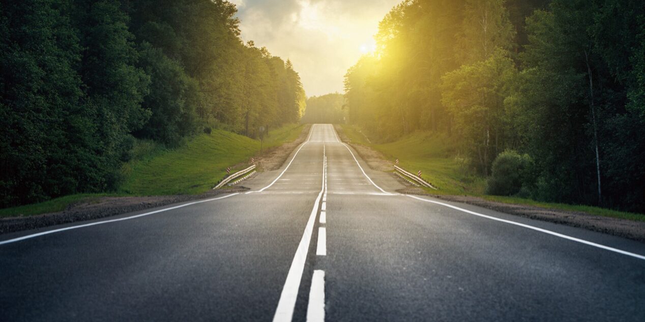 Tree Lined Open Road with Sunset in Distance