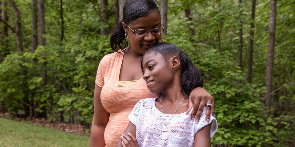 Mother and Daughter Leaning on One Another Smiling 
