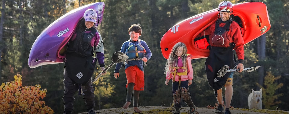 Couple loading skiing gear into the back of their GM vehicle