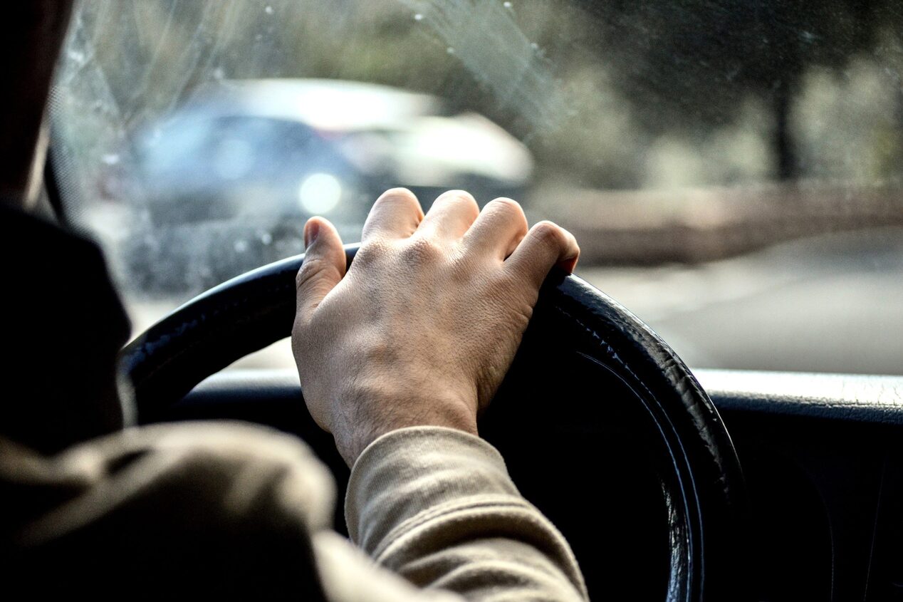 Close up of Steering Wheel with Someone Driving