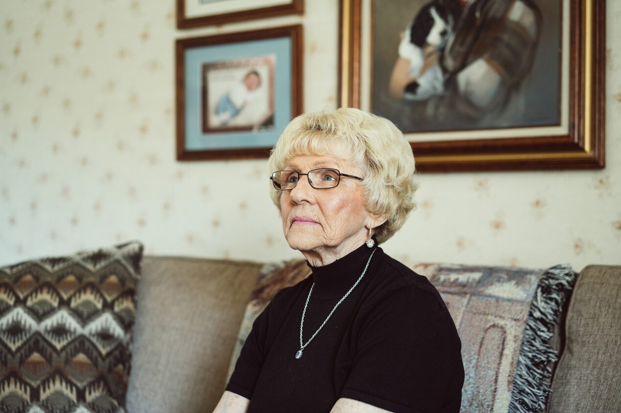 Older Woman Sitting on Her Couch Solemnly