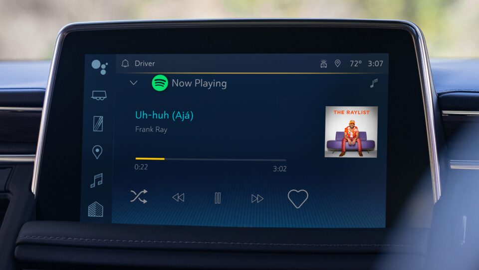 The infotainment screen displaying a song playing on spotify by Frank Ray.