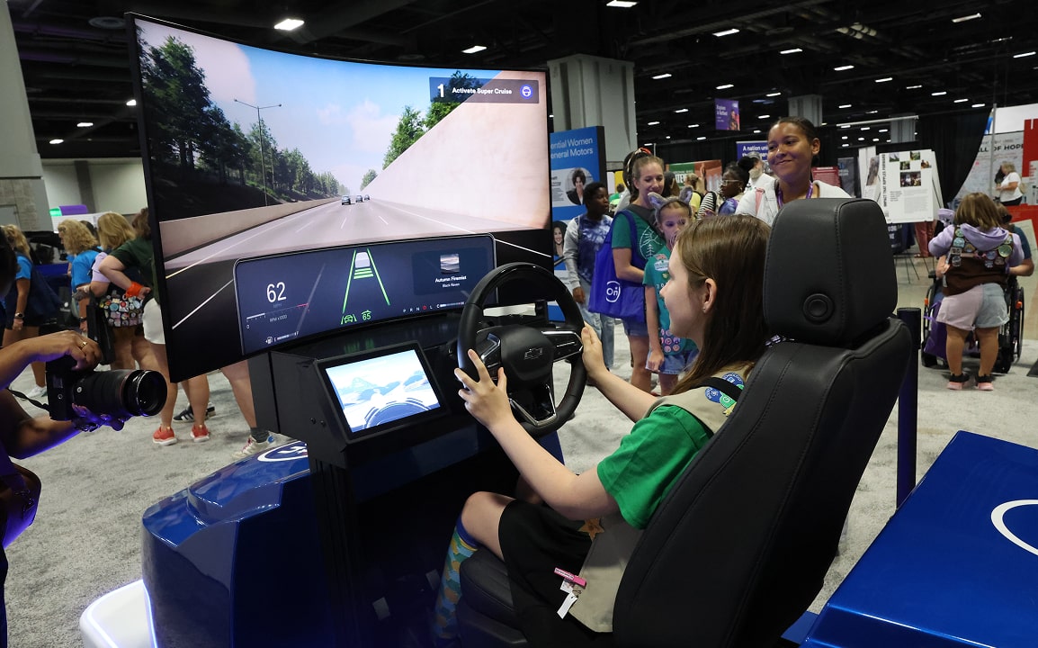 A young girl engages with a hands-on driving simulator at an OnStar educational event.
