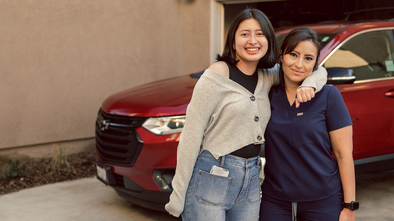 Glenis and her Daughter Hugging In Front of her Chevy Traverse