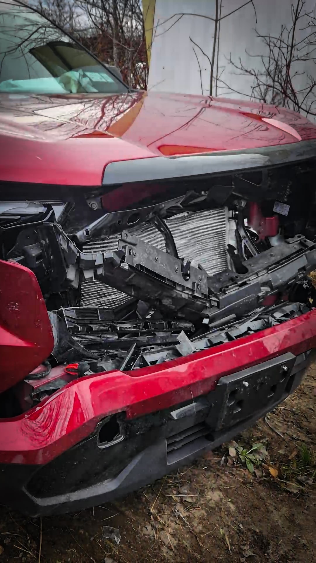 The heavily damaged front of a red GMC Terrain shows significant impact after a vehicle crash, highlighting OnStar's post-accident support.