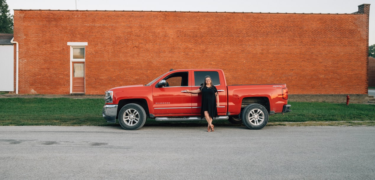 Woman Leaning on the Driver's Side of a GM Truck
