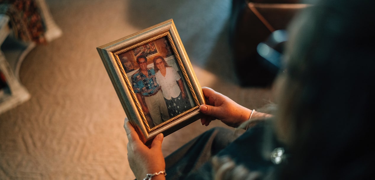 Family Member Looking at an Old Picture of a Couple
